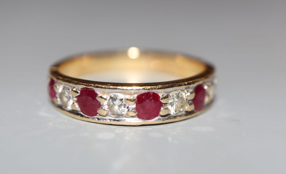 A modern 18ct gold, ruby and diamond set nine stone half hoop ring, size M, gross 3.2 grams.